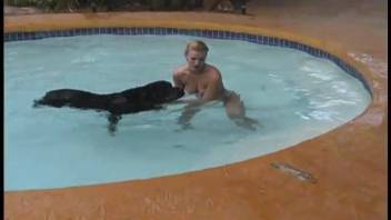 Voluptuous blonde babe is banged by a black canine by the poolside